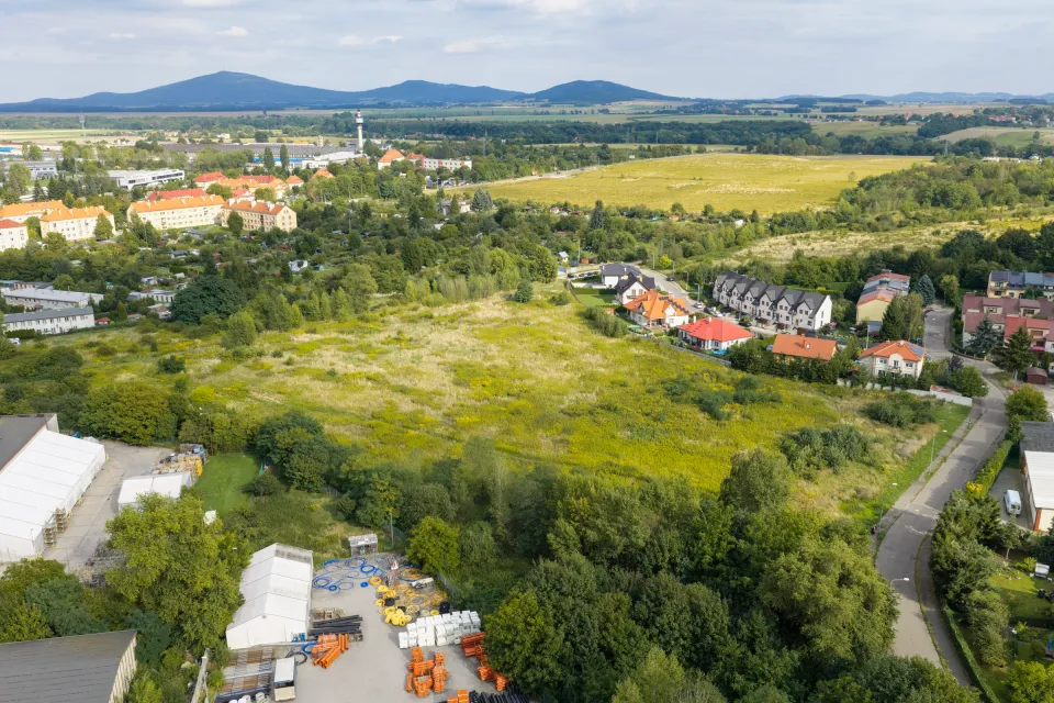 Działka w Świdnicy sfotografowana z drona — teren zielony, domy z czerwonymi dachami i krajobraz z wzgórzami