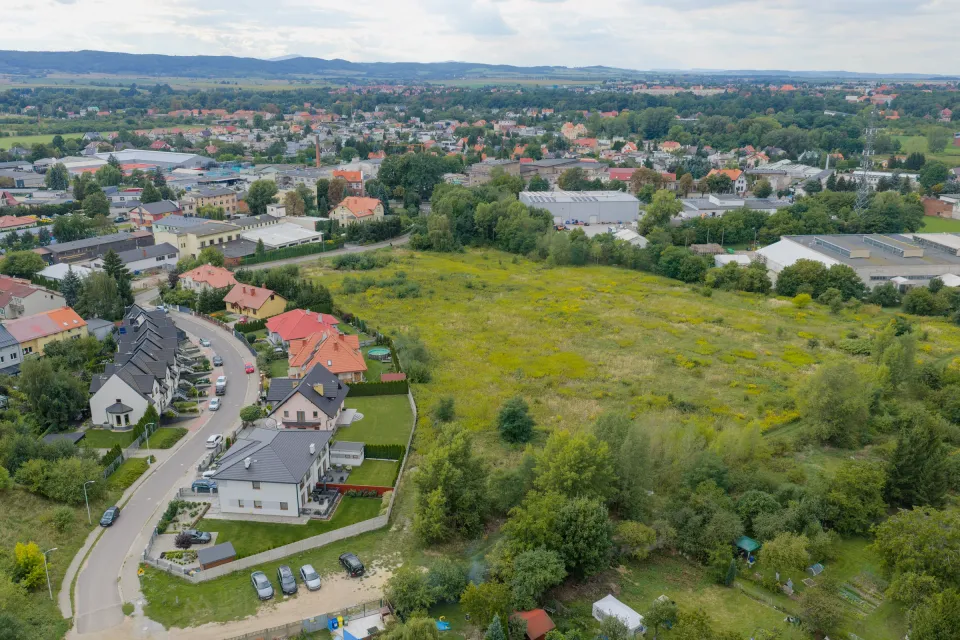 Działka w Świdnicy z drona — krawędź terenu przy zabudowie jednorodzinnej, ulica dojazdowa i panorama miasta